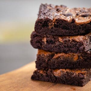 A stack of brownies on top of a wooden table.