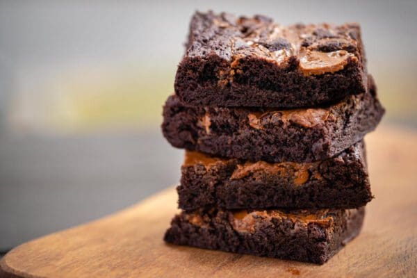 A stack of brownies on top of a wooden table.