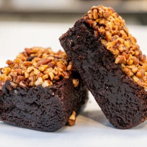 Two pecan brownies on white background.