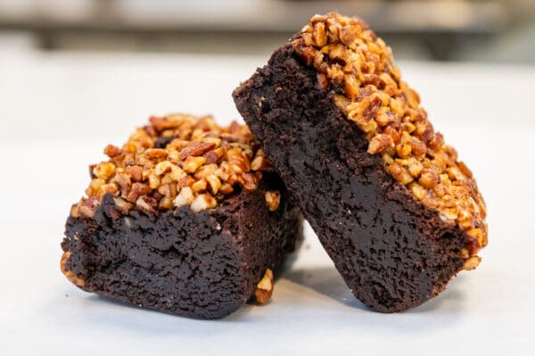 Two pecan brownies on white background.