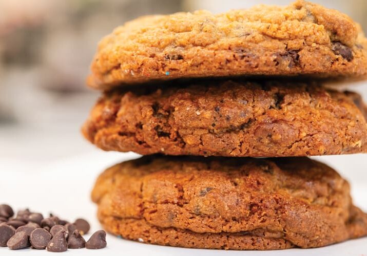 Three chocolate chip cookies stacked high.