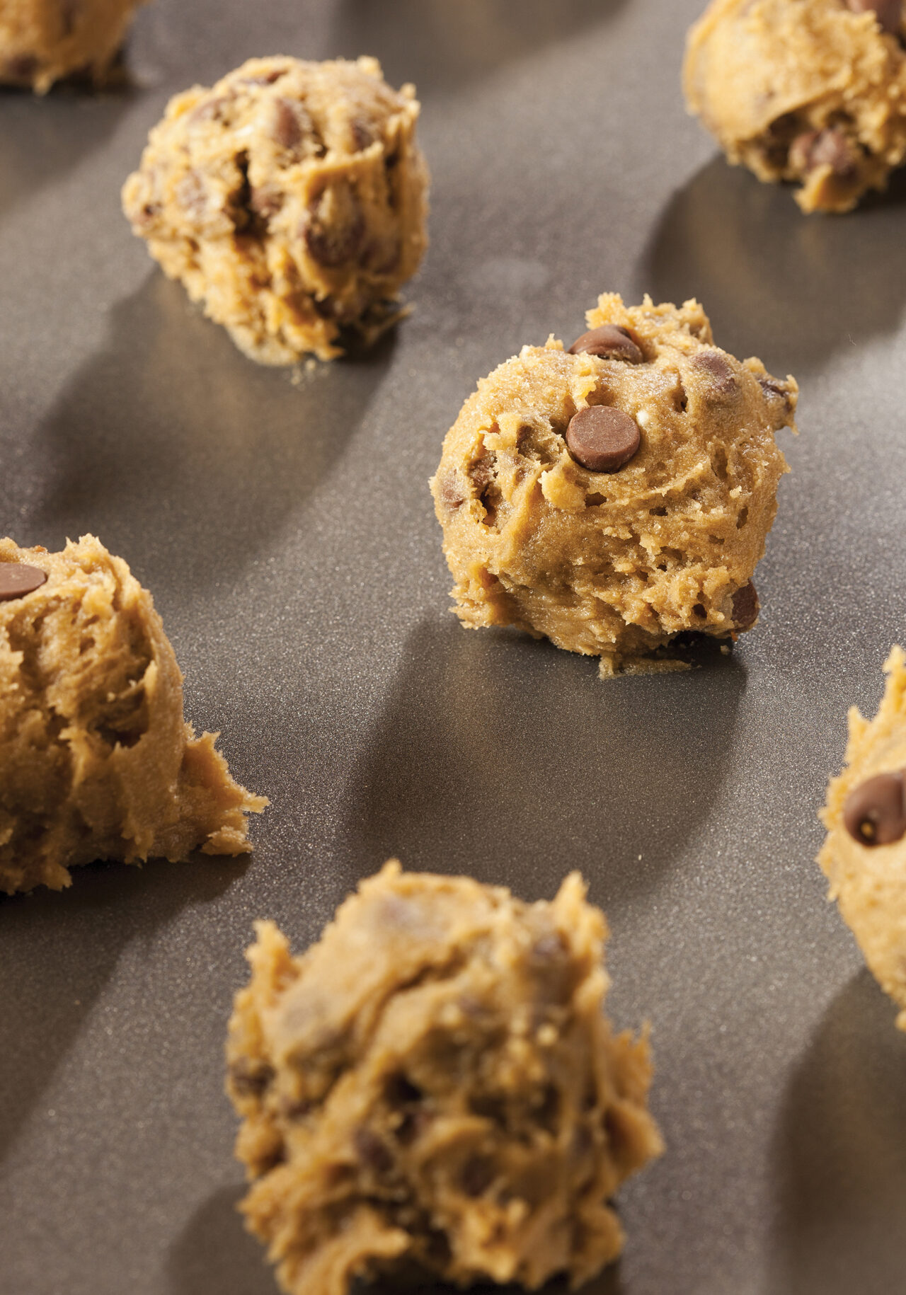 Chocolate chip cookie dough on baking sheet.