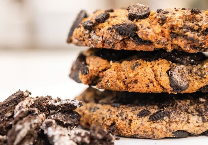 Stack of three Oreo cookies and crumbs.